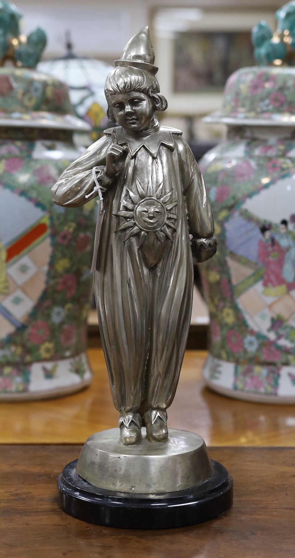 A large silvered bronze figure of a child dressed as a clown, 48cm